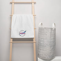 Serviette de bain NASA "Meatball" Transparent haut de gamme exclusive "NASA SHOP FRANCE". Fabriquée à partir d'un tissu absorbant de haute qualité et qui durera longtemps, que vous l'utilisiez à la maison ou à la plage. Elle est fabriquée à partir de 100 % coton peigné extra doux et moelleux. Broderie plate La broderie plate est une technique où les points sont brodés à plat sur le tissu, rien de plus beau sur une serviette de bain. Ce design est avec une broderie d'une épaisseur de 1,3 mm en 50x100